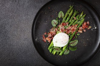 Asparagus with poached egg and fried bacon, micro greens and spices, breakfast, homemade, no people