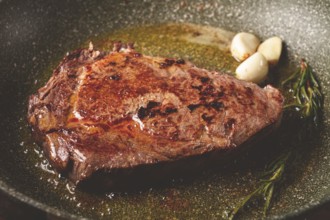 Fried steak, beef steak, rib eye steak, in a frying pan, top view, no people