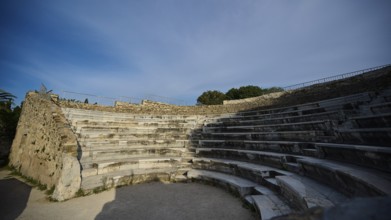 ©Udo Rein, Old amphitheatre with rows of stone seats under a clear sky, historical atmosphere,