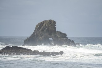 A rugged coastal landscape with rocks in the sea and a cloudy sky, Indian Beach, Oregon, USA, North