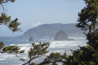 Sunny beach with large rocks in the sea and clear blue sky, peaceful and relaxing atmosphere,