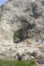Large rock with a hole and people in the foreground, Hole in The Wall, Rialto Beach, Olympic