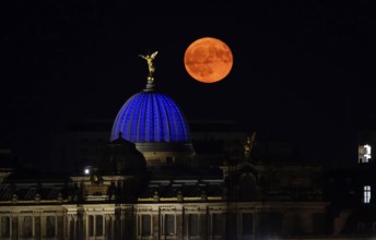 Glowing strawberry moon on 11 June 2025 over the Dresden University of the Arts, Saxony, Germany