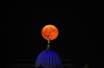 Glowing strawberry moon on 11 June 2025 over the Fama, Dresden University of the Arts, Saxony,