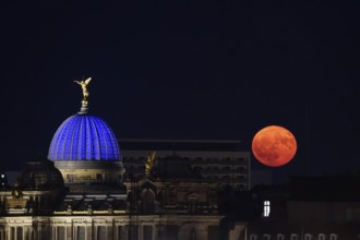 Glowing strawberry moon on 11 June 2025 next to the Dresden University of the Arts, Saxony, Germany