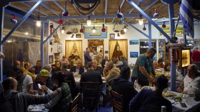 People dining in a cosy restaurant with traditional decoration, Skala, harbour, Gründonnertsga,