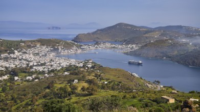 Panoramic view of a bay with town, ferry and surrounding landscape, Skala, harbour, Patmos,