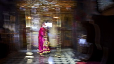 Zoodochou Pigis Monastery, Blurred image of a priest in red robes in a gold-decorated church