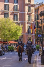 Horses with mounted police on a city street with people and cars, Palma de Mallorca, Mallorca,