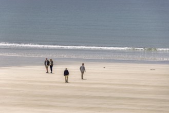 People walking on a sand beach by the sea a sunny summer day, Crozon peninsula, Bretagne, France