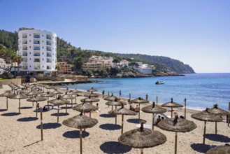 Sand beach with sunshades and sunbathing people at a tourist resort by the mediterranean sea, Sant