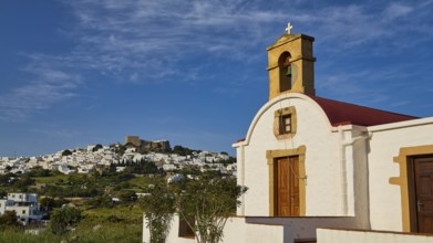 White chapel with cross and wooden door, village in the distance, chapel south of the Chora, World