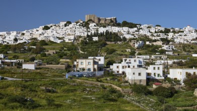 Whitewashed Mediterranean houses on a hill, crowned by an old fortress, Monastery of St John the