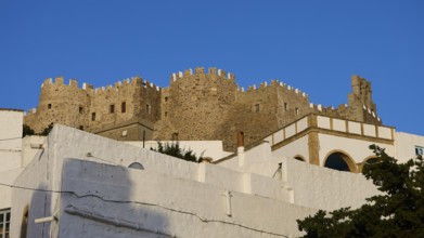 Majestic, historic castle above white buildings under a blue sky, Monastery of St John the