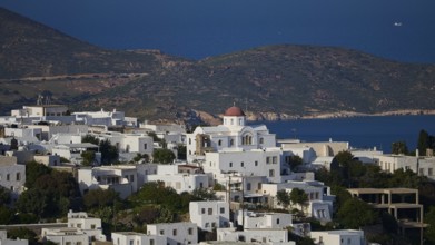 Whitewashed church with red roof in front of a coastal landscape and blue sea, World Heritage Site