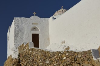White church with dome and cross on rocky ground under a clear sky, Church of the Prophet Elias,