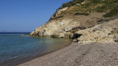 Stone beach under clear blue sky with coastline and water, Lambi Beach, Lambi Bay, Patmos,