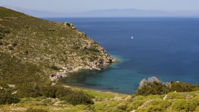 Sweeping views of turquoise blue sea and green hills with a narrow stretch of coastline,