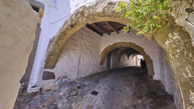 Old stone alleyway with arches and shade, offering a historic and cosy atmosphere, Chora, UNESCO