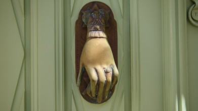 Detail of an ancient, hand-shaped door knocker on a green door, Chora, UNESCO World Heritage Site