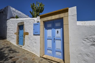 Residential houses with blue doors and cactus in the front garden, traditional Mediterranean