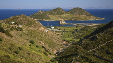 Hilly landscape with fields and coast, green and blue dominate the view, rocks of Kalikatsou,