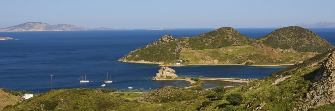 Panoramic view of sailing boats in front of mountains and a blue lake on an island, Rock of