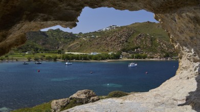 View from a cliff to the calm sea with boats and a green hilly coastal scene, cave, Chora, Grikos,