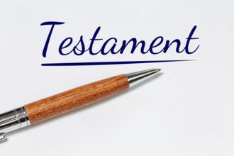 Symbolic image of a will: biros on a white sheet with added text TESTAMENT