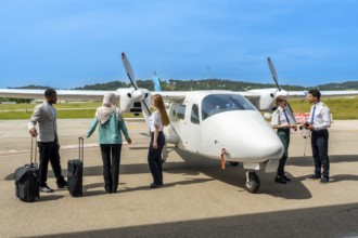 Pilots and passengers engaging in preparations for an upcoming flight on a small airplane at a
