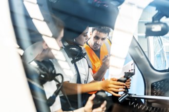 Instructor explaining aircraft controls to two pilot students during flight training inside cockpit