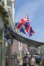 Union Jack flags on shops in street of historic buildings, The Strand, Dawlish, south Devon,