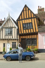Person taking phone photo of The Crooked House, Lavenham, Suffolk, England, UK