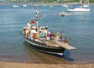 Shaldon ferry arriving, small boats in harbour at Back Beach, Teignmouth, south Devon, England, UK