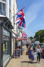 Union Jack flags on shops in street of historic buildings, The Strand, Dawlish, south Devon,