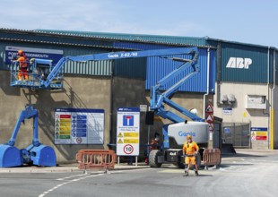 Man on cherry picker machinery cleaning sign, Port of Teignmouth, Teignmouth, south Devon, England,