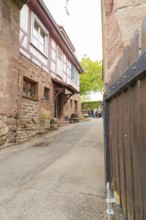 Narrow alley with traditional half-timbered houses and stone walls in a historic neighbourhood,