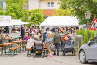 Lively street festival with many people at beer tent sets, cheerful and sociable atmosphere, family