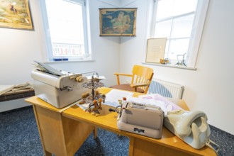 Old-fashioned office with typewriter, desk and chair, lit by daylight, family party in Neubulach,