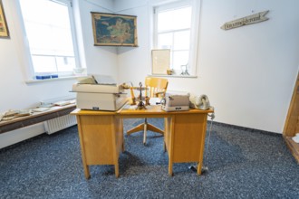 Historic office with old typewriters and telephones in a bright room, family party in Neubulach,