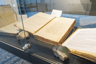 Old books with visible texts presented in a glass display case, family festival in Neubulach,