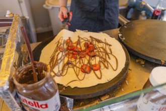 Preparation of a crepe with Nutella and strawberries in a lively kitchen, Calw railway station