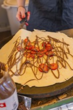 Crêpe with chocolate and strawberries being prepared on a hotplate, Calw railway station festival,