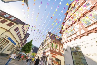 Colourful pennants span a picturesque street with half-timbered houses, Calw station festival,