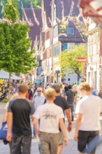 Lively city street with people and sun in summer, Calw railway station festival, Black Forest,