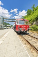 Red train waiting on the track under a blue sky, Calw railway station festival, Black Forest,