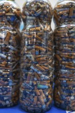 Plastic bottles filled with cigarette butts collected during cleanup efforts on a beach,