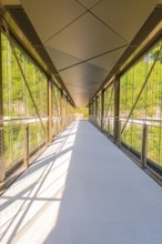 A modern glass and metal bridge with a shadow pattern in sunny weather, Zob extension with bridge