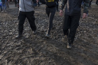 Festival visitors walk through mud in wellies at the Rock am Ring festival on Sunday, Nürburgring