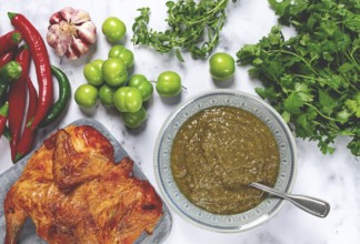 Tkemali sauce, made from green cherry plum, with ingredients on the table, tobacco chicken, top